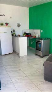 a green and white kitchen with a stove and refrigerator at Casa da orla in Aracati
