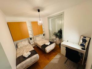 a small room with two beds and a desk at Hostel Arroios in Lisbon +69 photos