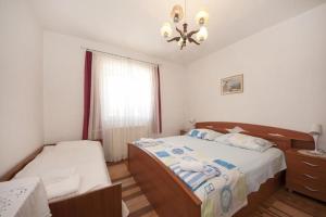 a bedroom with two beds and a chandelier at Two Bedroom Apartment with Terrace A1 in Splitska
