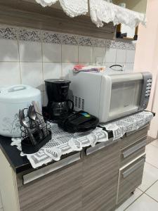 a kitchen counter with a microwave and a toaster at Flat na beira da praia in Maricá