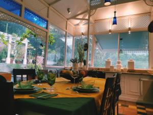 a dining room with a table with green plates and glasses at Villa Turrubares in San Pablo
