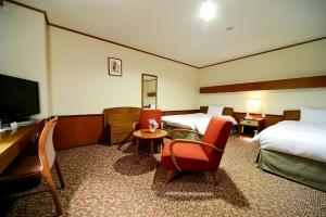 ein Hotelzimmer mit 2 Betten und einem Flachbild-TV in der Unterkunft Daiichi Inn Park in Sendai