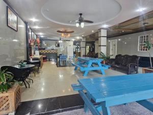 un restaurant avec des tables et des chaises de pique-nique bleues dans l'établissement China Town Hotel, à Caye Caulker