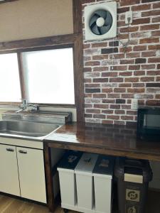 a kitchen with a sink and a brick wall at Kame in Niseko +25 photos