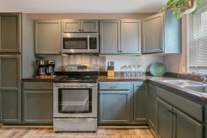 a kitchen with stainless steel appliances and blue cabinets at Ellis Hideaway in Fayetteville