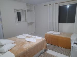 two beds with towels on them in a room at Casa 23 Alto do Mucuge in Porto Seguro