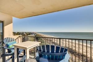 a balcony with a table and chairs and the beach at Walk to Beach Emerald Isle Condo with Ocean View! in Emerald Isle