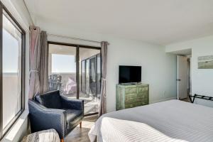 a bedroom with a bed and a chair and a window at Walk to Beach Emerald Isle Condo with Ocean View! in Emerald Isle