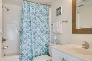 a bathroom with a toilet and a shower curtain at Walk to Beach Emerald Isle Condo with Ocean View! in Emerald Isle +20 photos