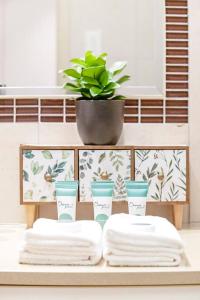 ein Tisch mit drei Handtüchern und einer Topfpflanze in der Unterkunft Tropical Horizons - Chic Family Stay with Pool in Darwin