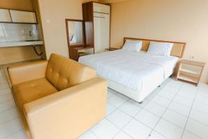 a hotel room with a bed and a couch at Aurora Rooms Mutiara Bekasi in Pekayon Satu