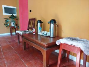 a room with a table with a thermos and two chairs at Hostal mil colores in Guacamayas