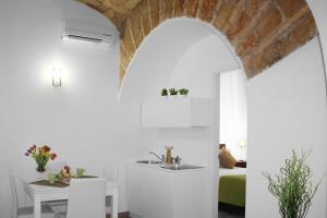 a kitchen and dining room with an archway and a table at Roma Resort Colosseum in Rome