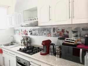 a kitchen with white cabinets and a red mixer at Departamento Completo Centro Historico in Mexico City +22 photos