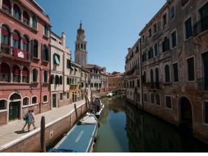 a canal in a city with buildings and a clock tower at Appartamento vista canale - Sant'Antonin in Venice