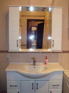 a bathroom with a sink and a mirror at Apartment Lux on Univermag Ukraina Center, 76 in Zaporozhye