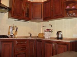 a kitchen with wooden cabinets and a counter top at Apartment Lux on Univermag Ukraina Center, 76 in Zaporozhye