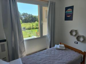 a bedroom with a bed and a window at Flores del Cerro in Tandil