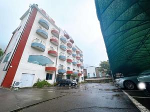 a large building with cars parked in a parking lot at Ulsan Yeongnam Alps Sandia Oncheon in Ulsan