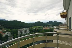 a balcony with a view of a city and mountains at Ulsan Yeongnam Alps Sandia Oncheon in Ulsan
