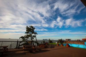 a deck with picnic tables and a view of the water at Byeonsanbando Stay Resort in Buan +20 photos