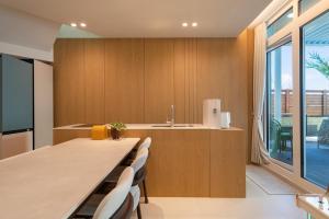a kitchen with a long table and chairs and a window at Gangneung Atopool Villa in Gangneung