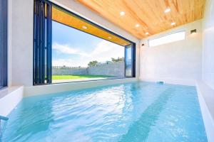 a swimming pool with a large window in a house at Taean Dog Day Pet Pool Villa in Taean