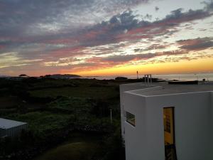 a sunset over the ocean and a building with the sky at Hello Gimnyeong in Jeju