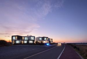 a house on the side of a road at sunset at Hello Gimnyeong in Jeju