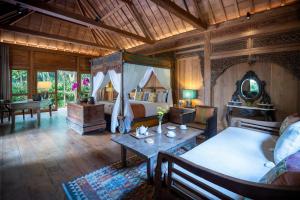 a bedroom with a bed and a table in a room at Villa Kapungkur in Jimbaran