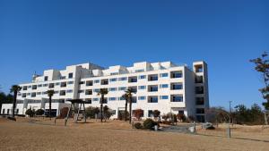 un edificio bianco con palme di fronte di Dasan Bearchae Golf N Resort a Kangjin