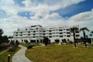 un grande edificio bianco con un parco di fronte di Dasan Bearchae Golf N Resort a Kangjin