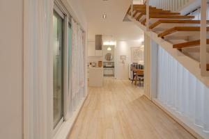 a hallway of a home with a staircase and a kitchen at Hug Jeju in Jeju