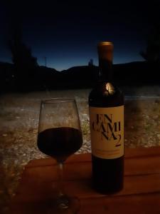 a bottle of wine next to a glass of wine at Cabañas Angualasto in Uspallata