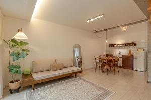a living room with a couch and a table at Jeju Byeolkkum Pension in Jeju