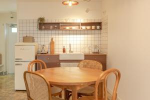 a kitchen with a table and chairs and a refrigerator at Jeju Byeolkkum Pension in Jeju +29 photos