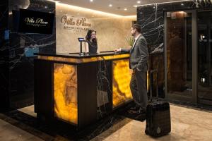 a man and a woman standing at a bar in a lobby at Villa Plaza Boutique Hotel & Spa in Prešov +37 photos