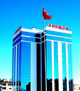 un edificio con una bandera roja encima de él en Anemon Grand Konya Otel, en Konya