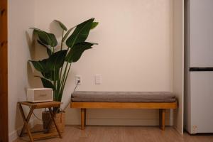a bench with a plant in the corner of a room at Jeju Sin-eom-an-gil A in Jeju