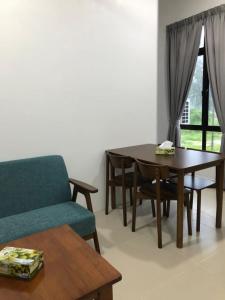 a living room with a table and a blue couch at KaLong Bay Homestay Villa Sakura Berdekatan Pantai in Kampong Telok Kalong