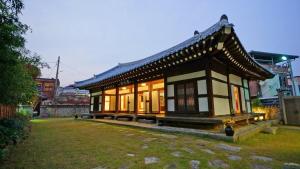 a small building with windows in a yard at Pungryuheon Hanok private house in Jeonju