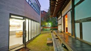 a building with a bench on the side of it at Pungryuheon Hanok private house in Jeonju
