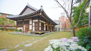a small building in a yard with flowers at Pungryuheon Hanok private house in Jeonju