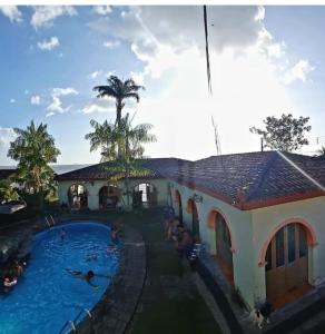 a swimming pool next to a building with people in it at Casa na praia do bispo pa in Mosqueiro