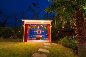 a small shed with a table in a yard at night at Its you Pool Villa in Jeju +12 photos