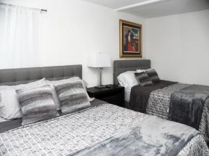 a bedroom with two beds and a table with a lamp at Welcome to Miami Springs Charm in Miami