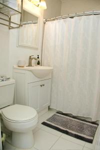 a white bathroom with a toilet and a sink at Welcome to Miami Springs Charm in Miami +41 photos