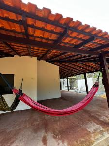 a red hammock hanging under a roof at Casa com 3 quartos em Alter do Chão in Santarém +4 photos