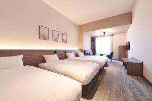 a row of beds in a hotel room at Hotel Grand Tiara Minaminagoya in Anjomachi