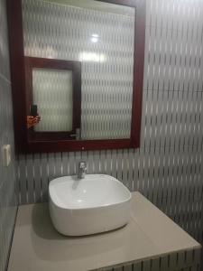 a white sink in a bathroom with a mirror at HOME STAY ME'SARI tulamben in Tulamben +18 photos